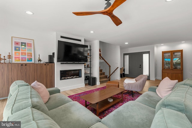 11111 Willow Bottom Dr, Columbia, MD 21044 - living room with stairway, light wood-type flooring, recessed lighting, ceiling fan, and a glass covered fireplace