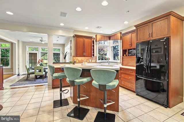 826 Bent Creek Dr, Lititz, PA 17543 - kitchen with freestanding refrigerator, light countertops, a kitchen bar, light tile patterned floors, and tasteful backsplash