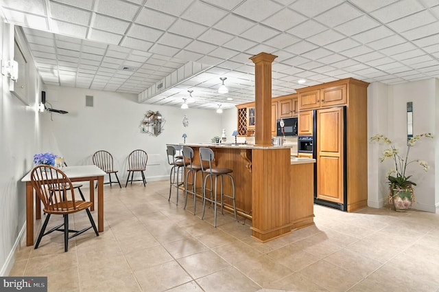 826 Bent Creek Dr, Lititz, PA 17543 - kitchen featuring black microwave, a breakfast bar area, baseboards, and light tile patterned floors
