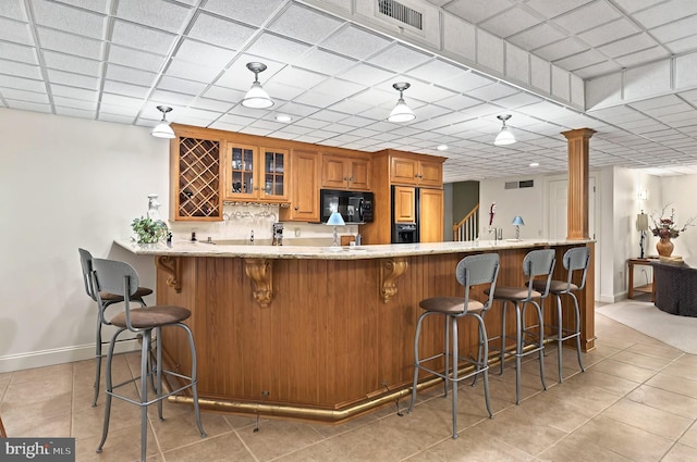 826 Bent Creek Dr, Lititz, PA 17543 - kitchen with black microwave, brown cabinetry, baseboards, glass insert cabinets, and light tile patterned floors