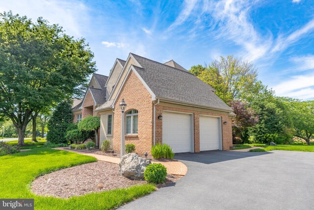 826 Bent Creek Dr, Lititz, PA 17543 - view of home's exterior featuring brick siding, a shingled roof, a yard, an attached garage, and asphalt driveway