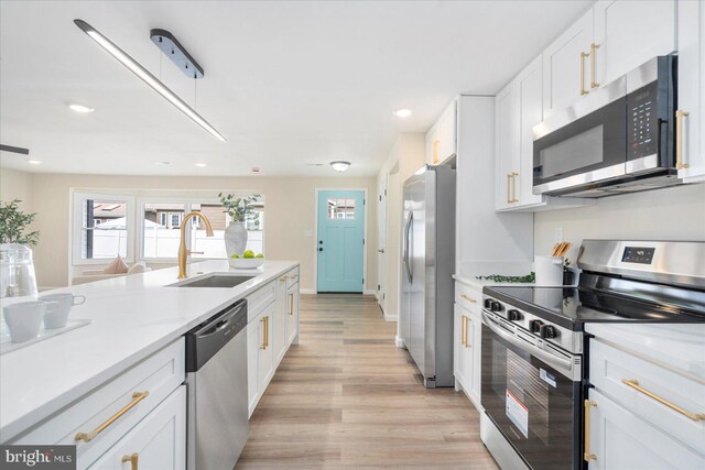 214 Kennard Ave, Edgewood, MD 21040 - kitchen with appliances with stainless steel finishes, a sink, white cabinetry, light wood-type flooring, and light countertops