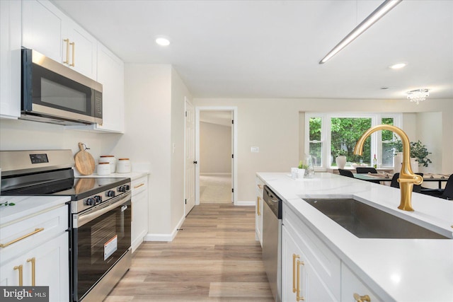 214 Kennard Ave, Edgewood, MD 21040 - kitchen featuring appliances with stainless steel finishes, a sink, light wood-type flooring, white cabinets, and recessed lighting