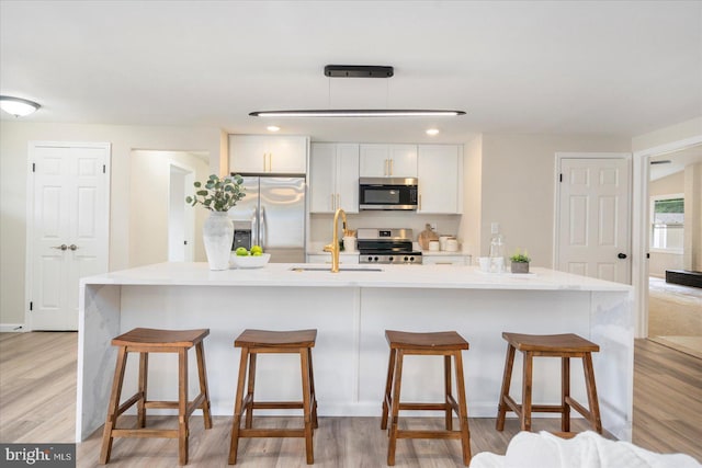 214 Kennard Ave, Edgewood, MD 21040 - kitchen with stainless steel appliances, a sink, white cabinets, light wood-style flooring, and light countertops