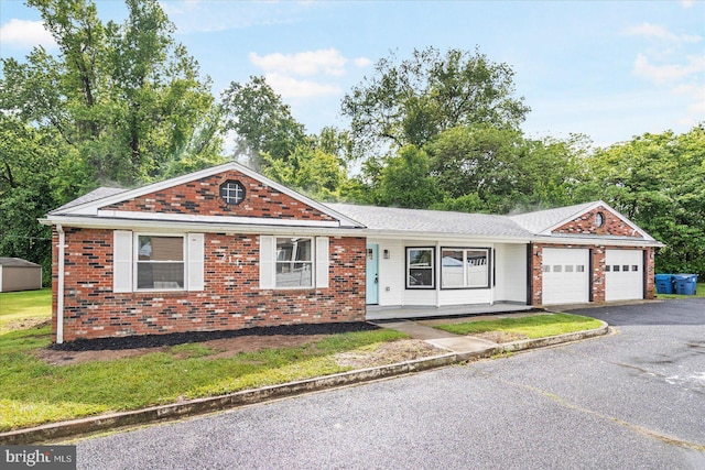 214 Kennard Ave, Edgewood, MD 21040 - ranch-style home featuring a garage, driveway, brick siding, covered porch, and a front yard