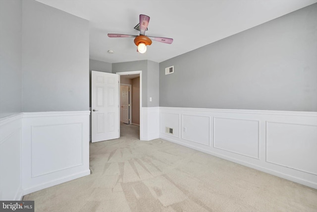 82 Grayson Ave, East Earl, PA 17519 - empty room with a decorative wall, light carpet, wainscoting, and ceiling fan