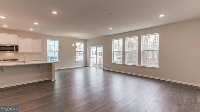 139 Erica Ln, Columbia, PA 17512 - kitchen featuring stainless steel microwave, light countertops, dark wood finished floors, baseboards, and a breakfast bar area
