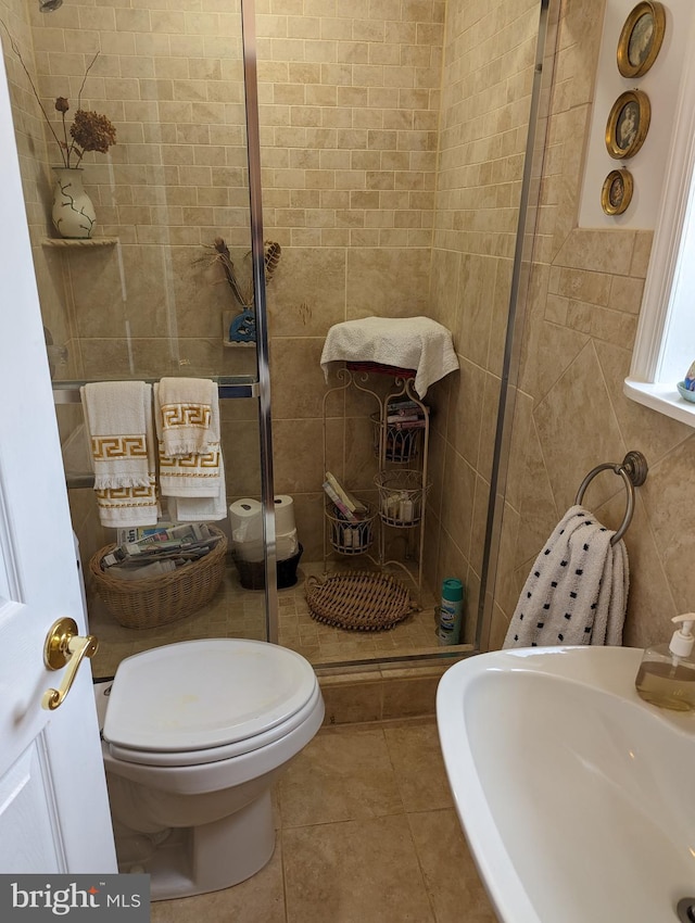 2834 E Boss Arnold Rd, Jefferson, MD 21755 - full bathroom with tile walls, a sink, a stall shower, tile patterned floors, and toilet