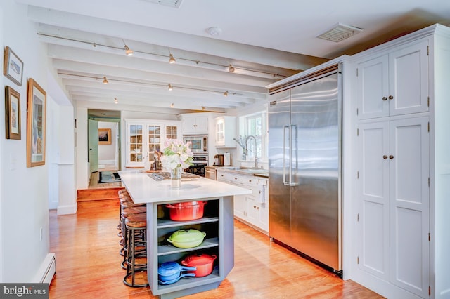 315 Linden Ave, Doylestown, PA 18901 - kitchen featuring built in appliances, a sink, open shelves, white cabinets, and beam ceiling