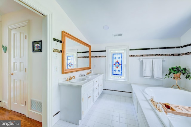 315 Linden Ave, Doylestown, PA 18901 - bathroom featuring a garden tub, double vanity, vaulted ceiling, and tile patterned floors