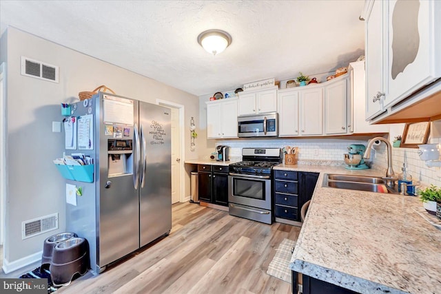 96 Billerbeck St, New Oxford, PA 17350 - kitchen with stainless steel appliances, a sink, light countertops, backsplash, and light wood-type flooring
