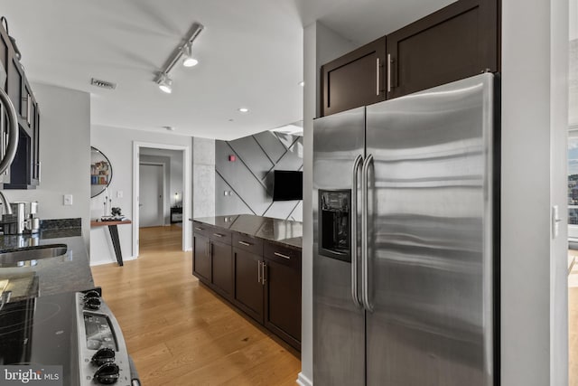 1200 Steuart St Unit 326, Baltimore, MD 21230 - kitchen featuring stainless steel refrigerator with ice dispenser, dark stone countertops, dark brown cabinets, and light wood-style floors