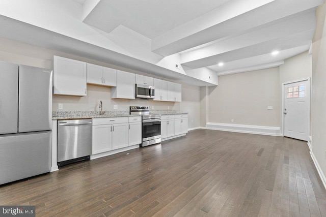 101 Poppleton St, Baltimore, MD 21201 - kitchen with stainless steel appliances, white cabinetry, dark wood-style floors, baseboards, and light stone counters