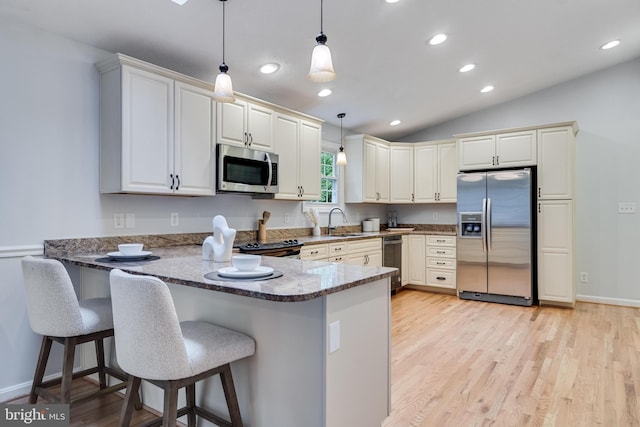 830 Willow Way, Prince Frederick, MD 20678 - kitchen with stainless steel appliances, a sink, a peninsula, hanging light fixtures, and light wood-type flooring