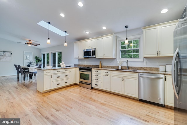 830 Willow Way, Prince Frederick, MD 20678 - kitchen featuring stainless steel appliances, a sink, a peninsula, a skylight, and light wood finished floors