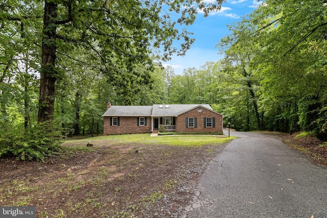830 Willow Way, Prince Frederick, MD 20678 - ranch-style house featuring brick siding, a chimney, a forest view, driveway, and a front lawn