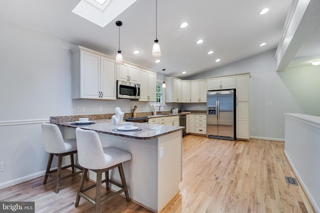 830 Willow Way, Prince Frederick, MD 20678 - kitchen featuring appliances with stainless steel finishes, a sink, a skylight, a peninsula, and dark stone counters