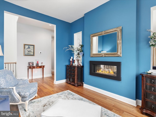 103 Titmouse Ct, Lake Frederick, VA 22630 - sitting room featuring wood finished floors, a glass covered fireplace, and baseboards