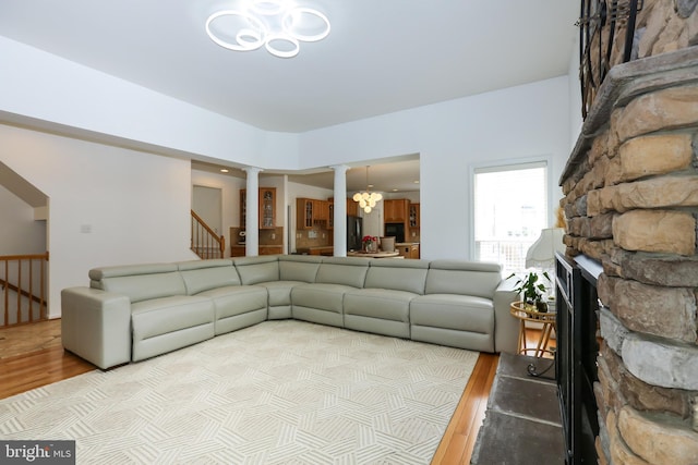 5736 Caribbean Ct, Haymarket, VA 20169 - living room featuring decorative columns, wood finished floors, a chandelier, and stairs