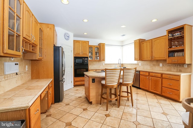 5736 Caribbean Ct, Haymarket, VA 20169 - kitchen featuring black appliances, tasteful backsplash, a kitchen bar, a center island, and recessed lighting
