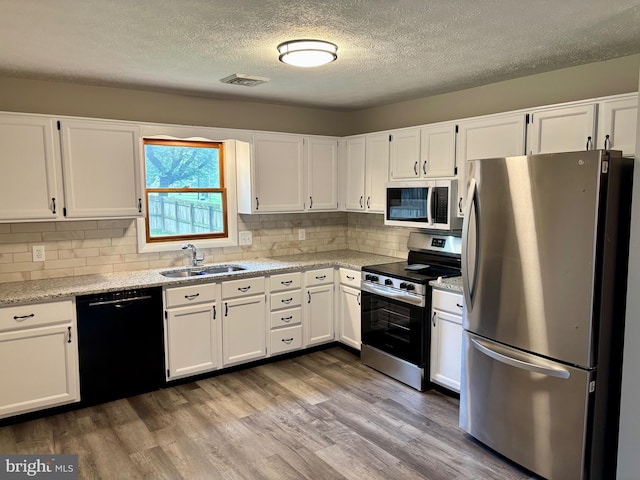 304 Rosedale Ave, Highspire, PA 17034 - kitchen with appliances with stainless steel finishes, a sink, white cabinets, a textured ceiling, and wood finished floors