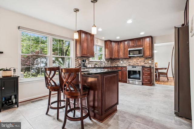 5441 Gladewright Dr, Centreville, VA 20120 - kitchen featuring appliances with stainless steel finishes, dark countertops, decorative backsplash, a breakfast bar, and baseboards