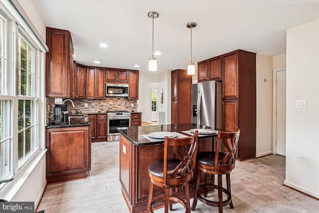 5441 Gladewright Dr, Centreville, VA 20120 - kitchen with stainless steel appliances, backsplash, a kitchen island, baseboards, and dark stone countertops