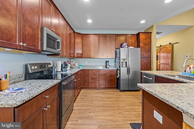 20843 Country Rd, Georgetown, DE 19947 - kitchen with appliances with stainless steel finishes, a sink, light wood-style flooring, light stone counters, and recessed lighting