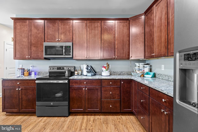 20843 Country Rd, Georgetown, DE 19947 - kitchen with stainless steel appliances, light wood-style floors, and light stone counters