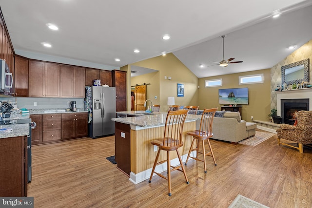 20843 Country Rd, Georgetown, DE 19947 - kitchen featuring appliances with stainless steel finishes, a sink, light wood-type flooring, open floor plan, and ceiling fan