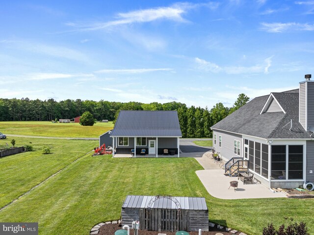20843 Country Rd, Georgetown, DE 19947 - rear view of property featuring a patio, a yard, driveway, and an outbuilding