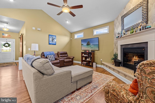 20843 Country Rd, Georgetown, DE 19947 - living area featuring a ceiling fan, wood finished floors, baseboards, a glass covered fireplace, and high vaulted ceiling