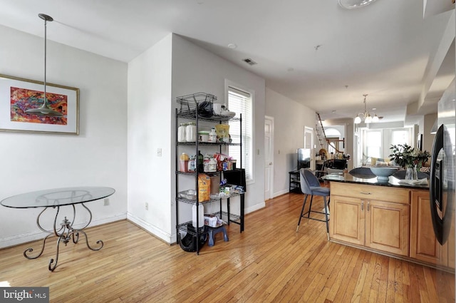 1316 Irving St NW, Washington, DC 20010 - kitchen with dark countertops, light wood finished floors, a chandelier, and baseboards