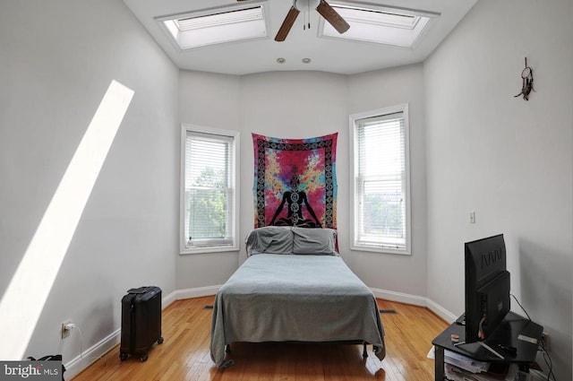 1316 Irving St NW, Washington, DC 20010 - bedroom featuring multiple windows, a skylight, light wood-type flooring, and baseboards