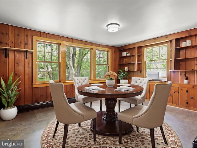 8301 Crestridge Rd, Fairfax Station, VA 22039 - dining space featuring wooden walls, built in shelves, and concrete floors