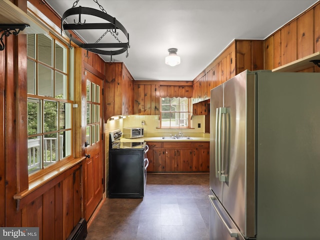 8301 Crestridge Rd, Fairfax Station, VA 22039 - kitchen with stainless steel appliances, brown cabinets, wooden walls, light countertops, and dark floors