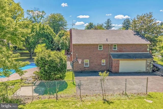7715 Doe Ln, Glenside, PA 19038 - view of side of property featuring brick siding, an attached garage, driveway, and a shingled roof