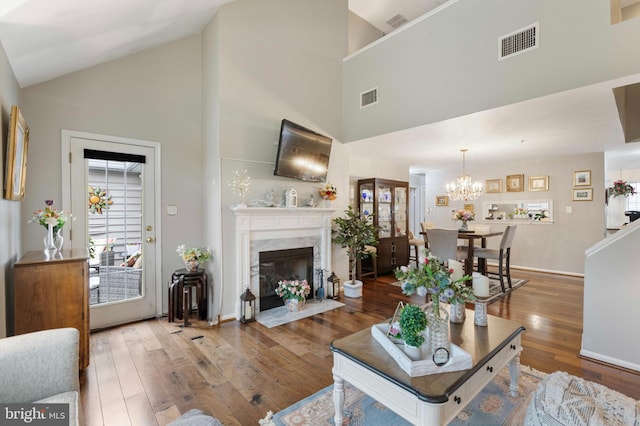 3214 Charing Cross Unit 18, Wilmington, DE 19808 - living room featuring high vaulted ceiling, wood-type flooring, a chandelier, a premium fireplace, and baseboards