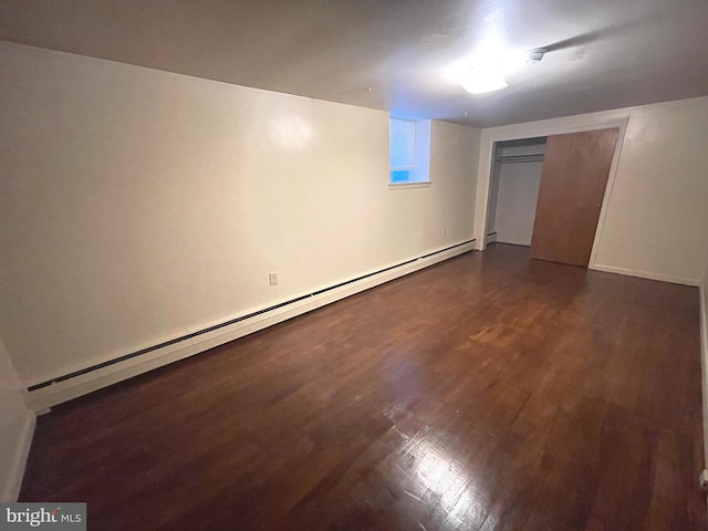 711 Oak Hill Ave, Hagerstown, MD 21740 - finished basement with a baseboard heating unit, dark wood-style flooring, and baseboards