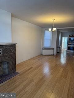2012 E Glenwood Ave, Philadelphia, PA 19124 - unfurnished living room featuring a chandelier, wood finished floors, and a fireplace