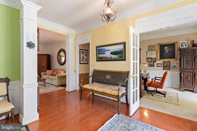 7482 Jeffreys Way, Easton, MD 21601 - living area featuring ornate columns, a wainscoted wall, wood finished floors, and crown molding