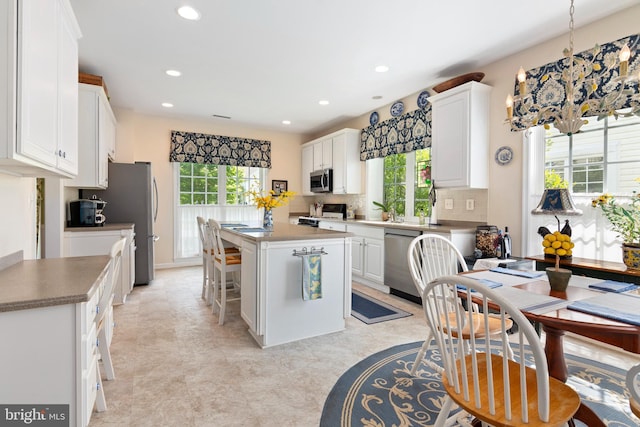 7482 Jeffreys Way, Easton, MD 21601 - kitchen with appliances with stainless steel finishes, white cabinetry, a center island, recessed lighting, and a breakfast bar