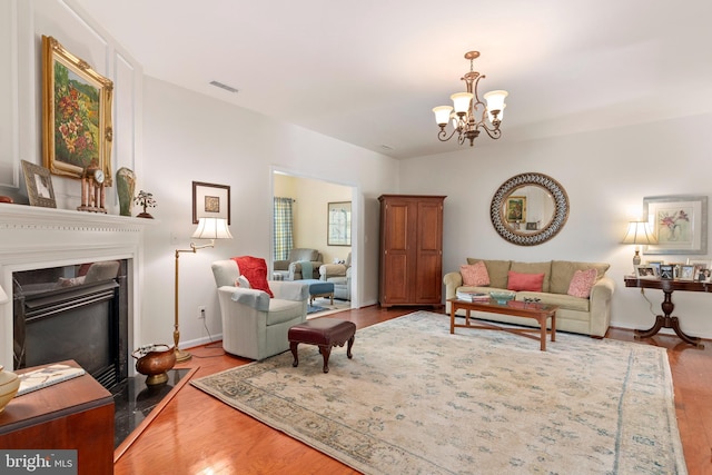 7482 Jeffreys Way, Easton, MD 21601 - living room with wood finished floors, a chandelier, a fireplace with flush hearth, and baseboards