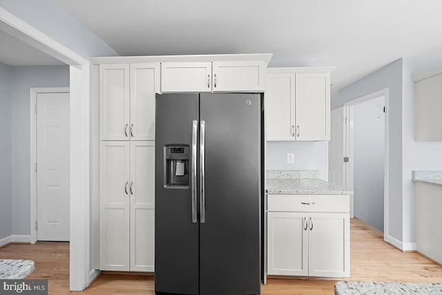 6712 Ridgecrest Rd, New Market, MD 21774 - kitchen with stainless steel refrigerator with ice dispenser, light wood-type flooring, white cabinets, light stone counters, and baseboards