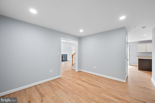6712 Ridgecrest Rd, New Market, MD 21774 - spare room featuring light wood-style floors, recessed lighting, baseboards, and a glass covered fireplace