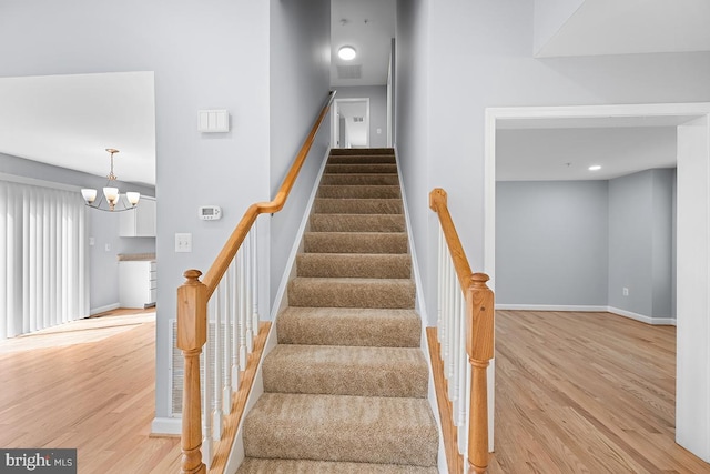 6712 Ridgecrest Rd, New Market, MD 21774 - stairway featuring wood finished floors, baseboards, and a chandelier