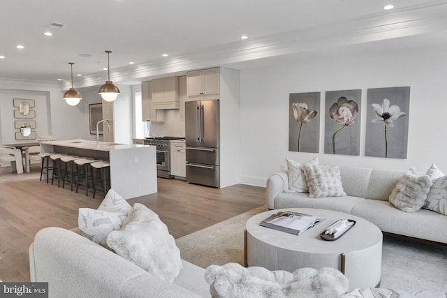 1335 11th St NW Unit Ph1, Washington, DC 20001 - living room featuring ornamental molding, recessed lighting, light wood-style flooring, and baseboards