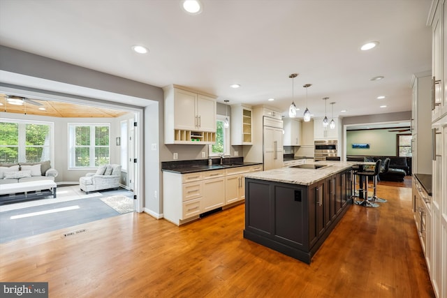 15221 Middlegate Rd, Silver Spring, MD 20905 - kitchen with open floor plan, a sink, wood finished floors, recessed lighting, and a center island