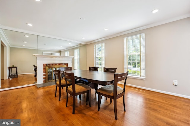 15221 Middlegate Rd, Silver Spring, MD 20905 - dining space with wood finished floors, a glass covered fireplace, baseboards, crown molding, and recessed lighting
