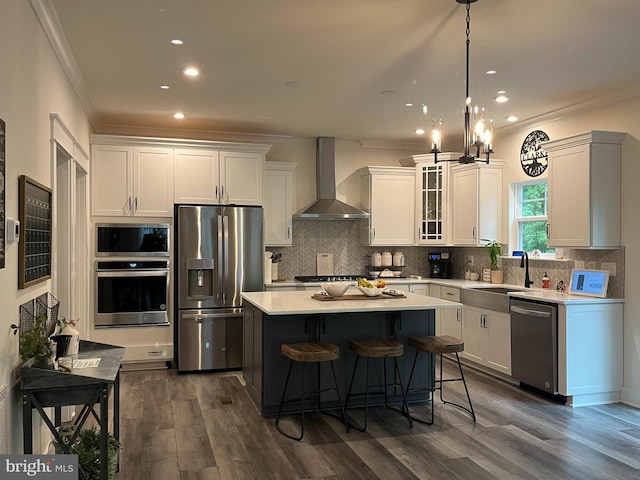 16801 Chalet Ct, Chesterfield, VA 23832 - kitchen featuring appliances with stainless steel finishes, wall chimney range hood, crown molding, a kitchen island, and light countertops